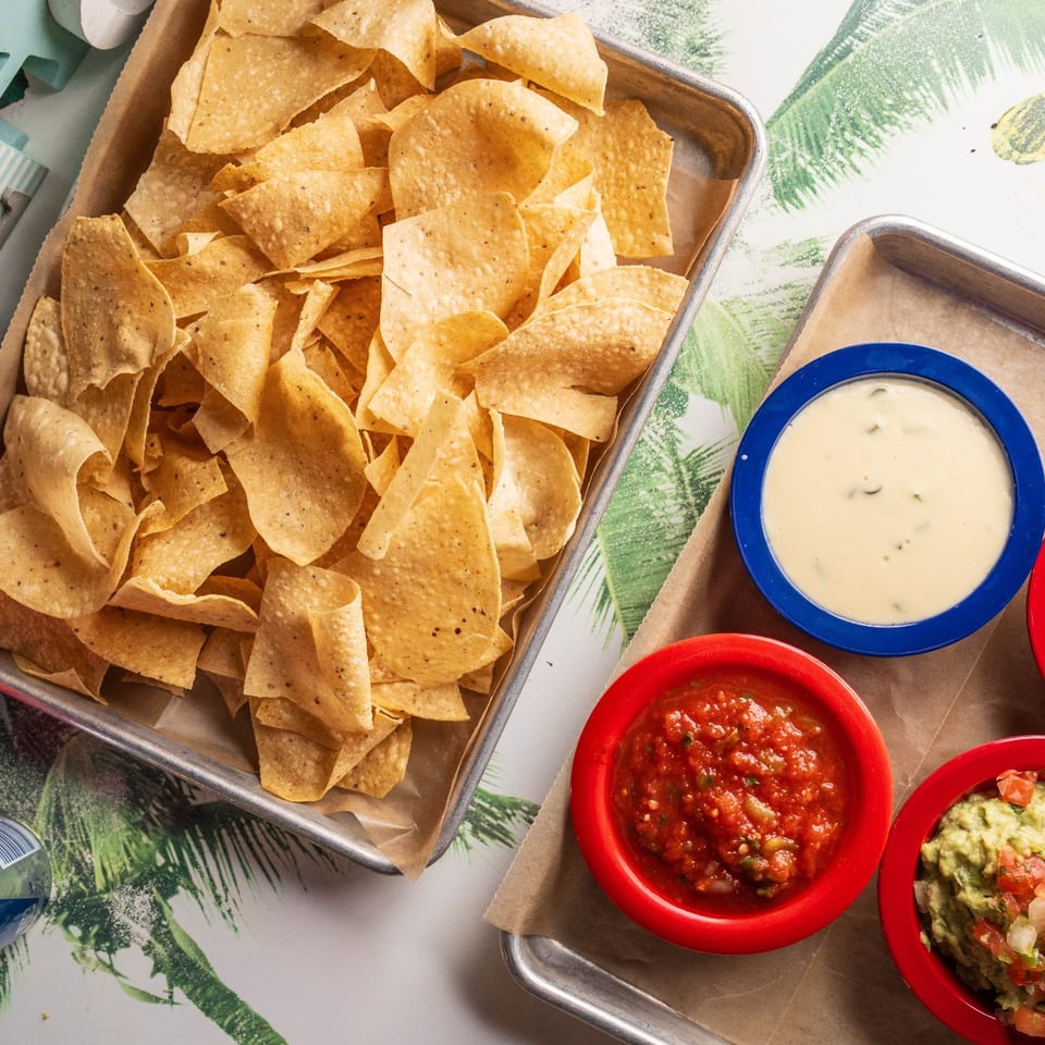 Tortilla chips served with queso, salsa, and guacamole.
