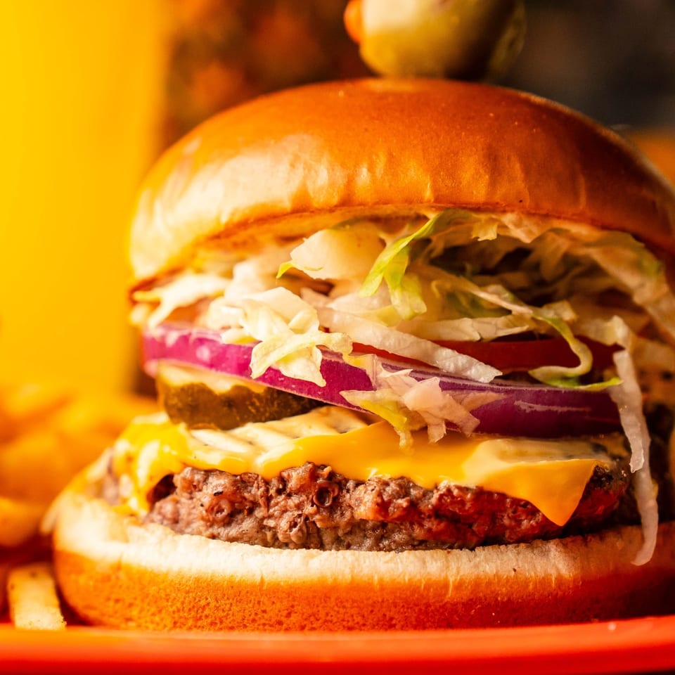 Kahuna Burger with cheese, lettuce, red onion, and fries.